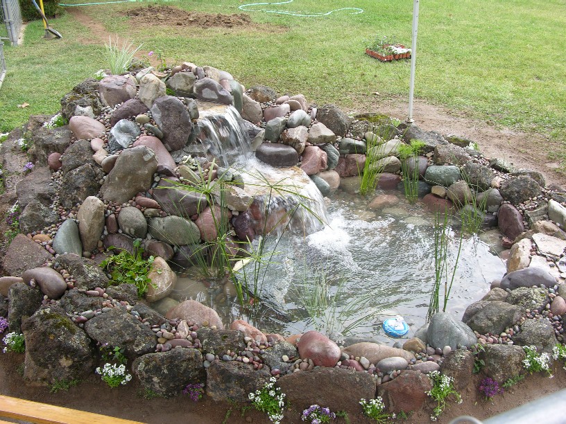 A small pond (5'x7') with one sheer waterfall then cascading down more boulders.